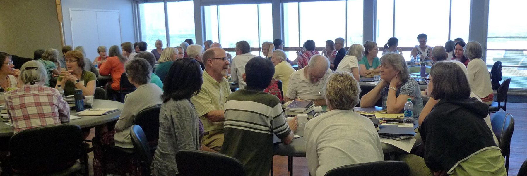 Mennonite spiritual directors gathered around tables at a retreat